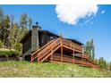 An inviting exterior view showcasing a multi-level deck and a wood-sided home against a bright blue sky at 34075 Grouse Ln, Evergreen, CO 80439