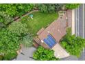 Aerial view of a home showcasing a large backyard, lush greenery, and solar panels on the roof at 13701 Yank Way, Arvada, CO 80004