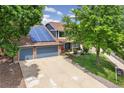 Attractive two-story home featuring a two-car garage, solar panels, and mature trees at 13701 Yank Way, Arvada, CO 80004
