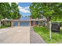Inviting front exterior with a well-maintained lawn, solar panels, and a real estate sign at 13701 Yank Way, Arvada, CO 80004