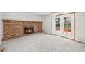Inviting living room featuring a brick fireplace and sliding glass doors to deck at 16835 E Harvard Pl, Aurora, CO 80013
