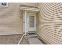 Close-up of the light and airy front door with a small porch and beige siding at 15912 E Dakota Pl # C, Aurora, CO 80017