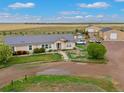 An aerial view showcasing the home, garages, and surrounding well maintained landscape at 47855 E 88Th Ave, Bennett, CO 80102