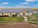 Home's front exterior showcasing well-manicured lawn and matching metal roof at 47855 E 88Th Ave, Bennett, CO 80102