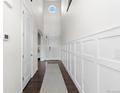 Bright and airy hallway with high ceilings, decorative wainscoting, and hardwood floors at 27596 E Jamison Cir, Aurora, CO 80016
