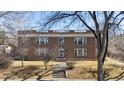 Brick apartment building with a manicured lawn and a walkway leading to the front entrance at 2034 Dahlia St # 1, Denver, CO 80207