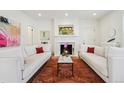 Bright living room with fireplace, white sofas with accent pillows and stylish area rug at 2034 Dahlia St # 1, Denver, CO 80207