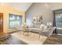 Bright living room featuring vaulted ceilings, large windows, modern furniture, and stylish decor at 2777 W 106Th Cir, Denver, CO 80234