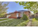 Cozy brick home with a neatly manicured lawn, complemented by a small front porch at 7875 Cyd Dr, Denver, CO 80221