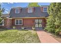 Traditional home exterior showing a red brick walkway leading to an ornate wrought iron front door at 3825 S Peach Way, Denver, CO 80237