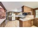 Traditional kitchen with wood cabinetry, tile countertops, and modern appliances at 3825 S Peach Way, Denver, CO 80237