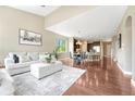 Open-concept living area featuring a comfortable sofa, dining table, and hardwood floors at 19382 Dunraven St, Parker, CO 80134