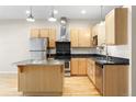 Well-equipped kitchen with stainless steel appliances, light wood cabinetry, and a functional center island for meal preparation at 1440 Little Raven St # 110, Denver, CO 80202