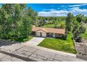 Beautiful home with a well-kept lawn, paved driveway, and lush greenery, showcasing its curb appeal at 11310 W 46Th Ave, Wheat Ridge, CO 80033