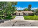 Attractive house with a spacious driveway, brick facade, mature trees, and a well-manicured lawn at 11310 W 46Th Ave, Wheat Ridge, CO 80033