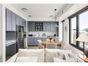 Modern kitchen with stainless steel appliances and grey cabinets, connecting to dining area and bright windows at 1750 Wewatta St # 1230, Denver, CO 80202