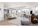 Bright living area with sofa, expansive windows offering city views, and an adjacent modern kitchen at 1750 Wewatta St # 1230, Denver, CO 80202