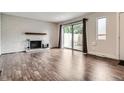 Comfortable living room with white brick fireplace, hardwood floors and access to outdoor space at 9605 E Kansas Cir # 53, Denver, CO 80247
