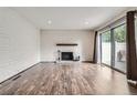 Spacious living room with hardwood flooring, brick fireplace and access to outdoor deck at 9605 E Kansas Cir # 53, Denver, CO 80247
