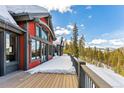 Exterior of home with multiple windows and snow covered deck overlooking mountain view at 1279 Estates Dr, Breckenridge, CO 80424