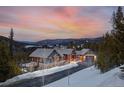 Beautiful exterior of mountain home features stone and siding, and stunning sunset views at 1279 Estates Dr, Breckenridge, CO 80424
