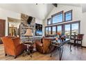 Cozy living room boasts stone fireplace, vaulted ceiling, and large windows with picturesque views at 1279 Estates Dr, Breckenridge, CO 80424
