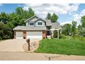 Inviting home with a two-car garage, lush lawn, and a charming walkway leading to the entrance at 7999 Centrebridge Dr, Niwot, CO 80503