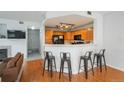 Open kitchen with wood cabinets, breakfast bar, and black appliances overlooking the living area at 8707 E Florida Ave # 510, Denver, CO 80247