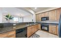 Cozy kitchen featuring granite countertops, tiled floors and wooden cabinets with modern appliances at 2500 E Cherry Creek South Dr # 213, Denver, CO 80209
