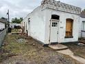 Corner view of a small white brick home with damage and incomplete repairs at 1037 Hazel Ct, Denver, CO 80204