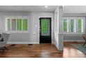 Inviting entryway featuring a decorative glass door, hardwood floors, and views to bright, shuttered windows at 1366 S Vine St, Denver, CO 80210