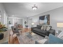 Bright living room with hardwood floors, stylish gray furniture, and an open layout to the dining area, perfect for entertaining at 1366 S Vine St, Denver, CO 80210