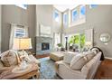Cozy living room with a stone fireplace, large windows, and stylish furniture, perfect for relaxing at 4378 Fell Mist Way, Castle Rock, CO 80109