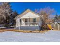 Craftsman home with front porch, snowy yard, and mature trees at 202 Lower Glenway St, Palmer Lake, CO 80133