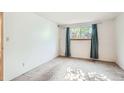 This bedroom features white walls, carpeted flooring, and a window with curtains at 7755 E Quincy Ave # 104A6, Denver, CO 80237