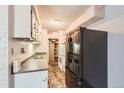 Functional kitchen features a black refrigerator, white cabinets, and tiled flooring at 7755 E Quincy Ave # 104A6, Denver, CO 80237