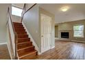 Inviting entryway featuring hardwood floors, a staircase, and a glimpse of a living area with a fireplace at 2253 E 100Th Pl, Thornton, CO 80229