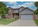 Charming home featuring brick accents, a covered porch, mature landscaping, and a spacious two-car garage at 2253 E 100Th Pl, Thornton, CO 80229