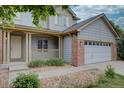 A well-manicured lawn, brick and siding facade, covered porch and a two-car garage enhance this home's curb appeal at 2253 E 100Th Pl, Thornton, CO 80229