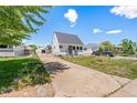 Street view of house featuring manicured lawn, long driveway, inviting curb appeal and a detached garage at 235 S 8Th Ave, Brighton, CO 80601