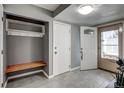 Inviting entryway with gray tile flooring, coat rack and bench seating at 2829 S Xanadu Way, Aurora, CO 80014