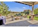 Backyard patio with fire pit and outdoor seating overlooking scenic views and green space at 10492 Willowwisp Way, Highlands Ranch, CO 80126
