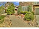 Landscaped front yard featuring a stone pathway, mature shrubs, and decorative rocks at 10492 Willowwisp Way, Highlands Ranch, CO 80126