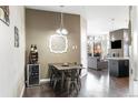 Dining area boasts sleek table and chairs, designer lighting, wine storage, and open floorplan to living room at 336 E 1St Ave # 209, Denver, CO 80203