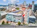Aerial view of the building highlighting the unit location with a red arrow and the cityscape in the background at 55 W 12Th Ave # 512, Denver, CO 80204