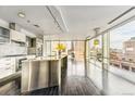 Modern kitchen featuring stainless steel island, high-end appliances, and floor-to-ceiling windows with city views at 55 W 12Th Ave # 512, Denver, CO 80204
