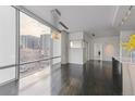 Bright living room with dark wood floors, a modern chandelier, and expansive windows offering panoramic city views at 55 W 12Th Ave # 512, Denver, CO 80204
