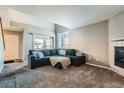 Spacious living room with plush carpeting, fireplace, and abundant natural light from the window at 2900 Purcell St # I4, Brighton, CO 80601