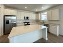 Bright, spacious kitchen with stainless steel appliances and a large center island at 586 Nightsky St, Erie, CO 80516