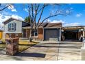 House exterior featuring brick and gray siding, a driveway, and landscaping at 16357 E Wyoming Dr, Aurora, CO 80017